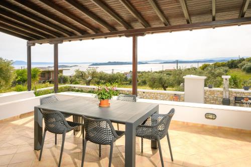 einen Tisch und Stühle auf einer Terrasse mit Meerblick in der Unterkunft VILLA MANTI in Ouranoupoli