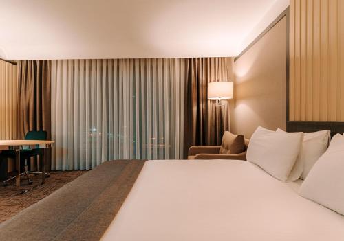 a hotel room with a large bed and a desk at Invite Hotel Corner Trabzon in Trabzon