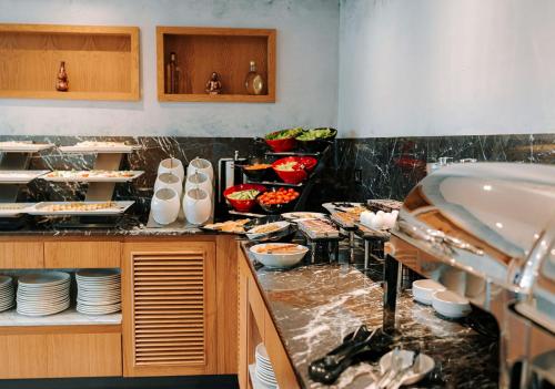 a kitchen with a counter with dishes and a sink at Invite Hotel Corner Trabzon in Trabzon