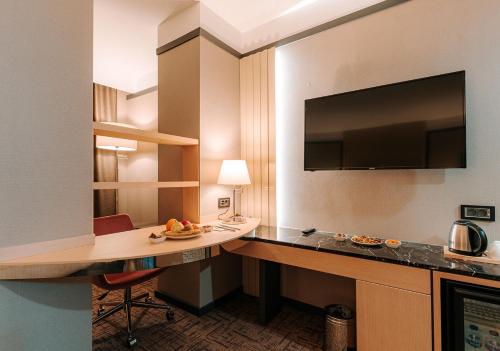 a hotel room with a desk and a flat screen tv at Invite Hotel Corner Trabzon in Trabzon