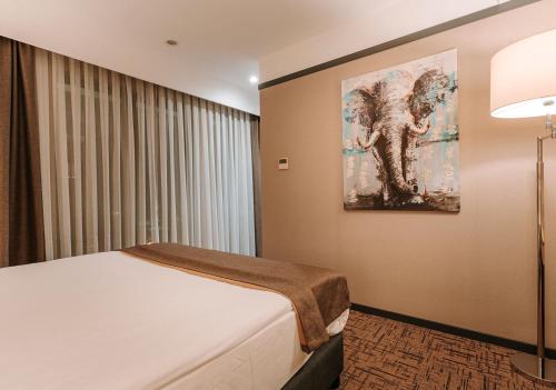 a bedroom with a bed and a painting on the wall at Invite Hotel Corner Trabzon in Trabzon