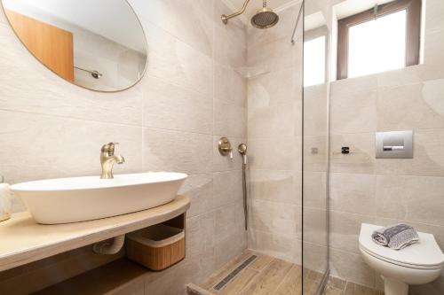 a bathroom with a sink and a shower at Vozas Villas - Traditional Houses with Great View in Tragaki