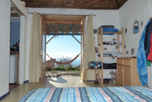 1 dormitorio con 1 cama y puerta con ventana en Casita en el campo con vista al oceano, en Tijarafe