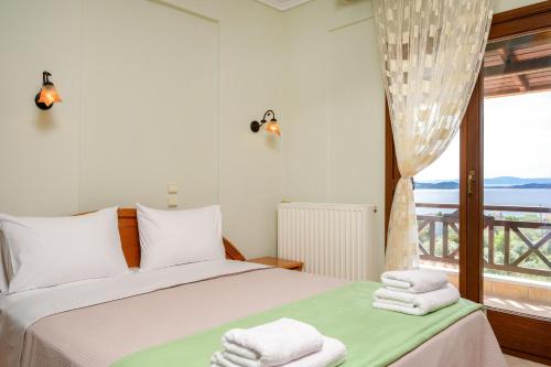 a bedroom with a bed and a window with a view at VILLA MANTI in Ouranoupoli