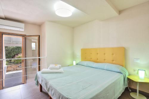una camera con un grande letto e una finestra di La Perugina by DomusAway a Monte Petrosu
