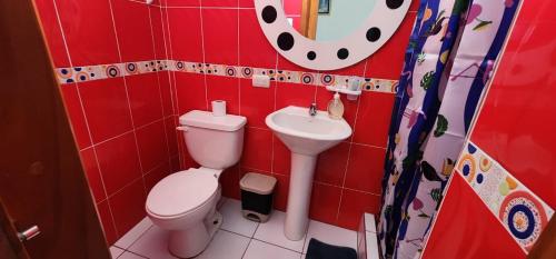 uma casa de banho vermelha com um WC e um lavatório em Hostal Poseidon - Neptuno em Puerto Villamil