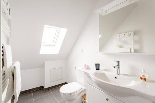 Baño blanco con aseo y lavamanos en Joli appartement proche Paris Orly, en Morangis