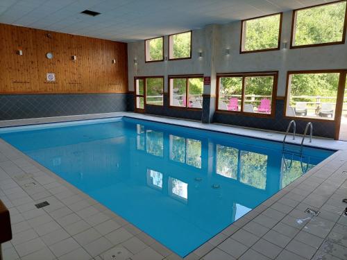 une piscine avec de l'eau bleue dans un immeuble dans l'établissement Le Valmignon, à Valmeinier