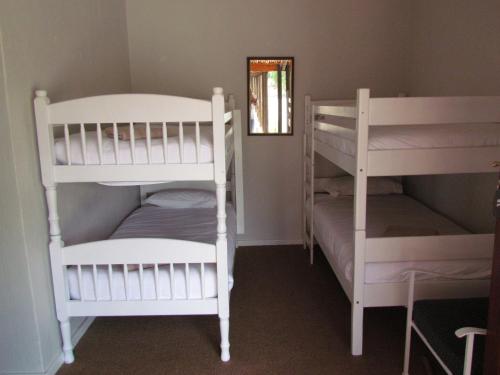 a room with two bunk beds and a mirror at Wagon Wheel Country Lodge in Beaufort West