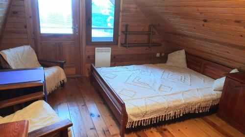 a bedroom with two beds in a log cabin at Lawendowe Narie in Kretowiny