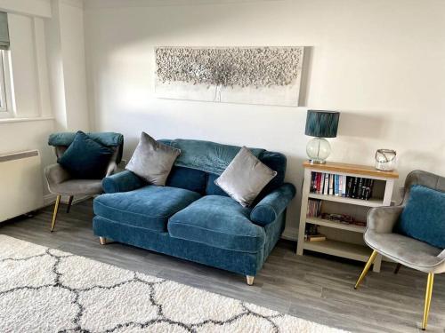 a living room with a blue couch and two chairs at Cottage in Par, 4mi. from Fowey in Saint Blazey