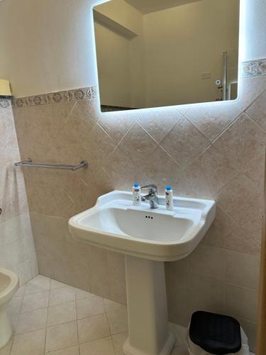 y baño con lavabo y espejo. en Hexagon Home (intero appartamento), en Villa San Giovanni