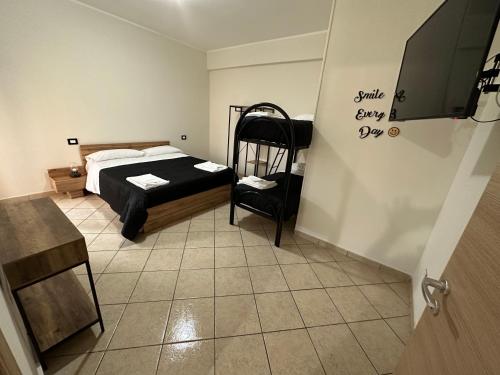 1 dormitorio pequeño con 1 cama y 1 silla en Hexagon Home (intero appartamento), en Villa San Giovanni