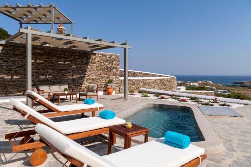 een villa met een zwembad en een patio bij Peters Place - Paros Resort in Parasporos