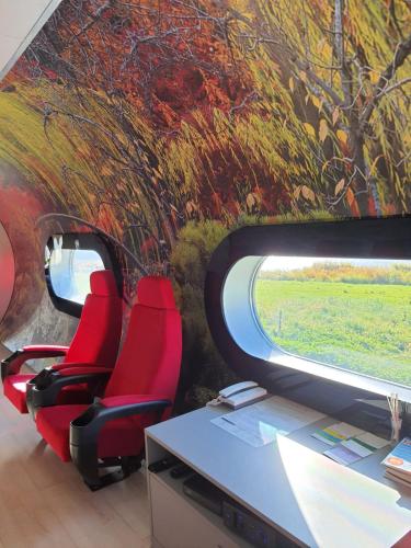um escritório com cadeiras vermelhas e um quadro num comboio em normobaria Górki em Wiślica