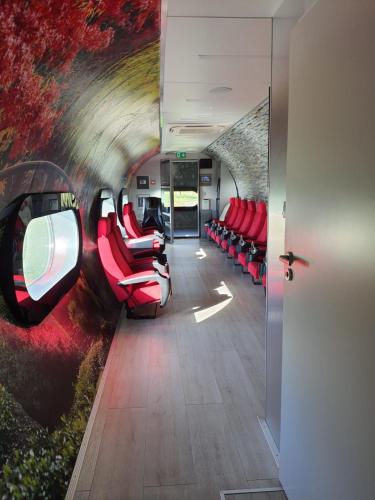 uma sala de comboios com cadeiras vermelhas e um túnel em normobaria Górki em Wiślica