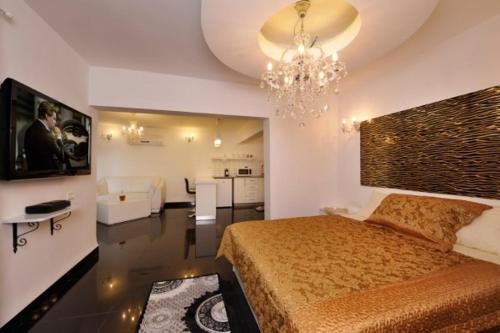 ein Schlafzimmer mit einem großen Bett und einem Kronleuchter in der Unterkunft זריחת הירדן בכנרת - סוויטות יוקרה in Poriyya