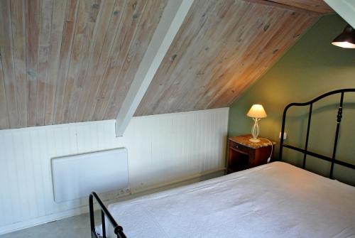 een slaapkamer met een bed en een houten plafond bij Sur le sentier des douaniers 3 in Ploubazlanec