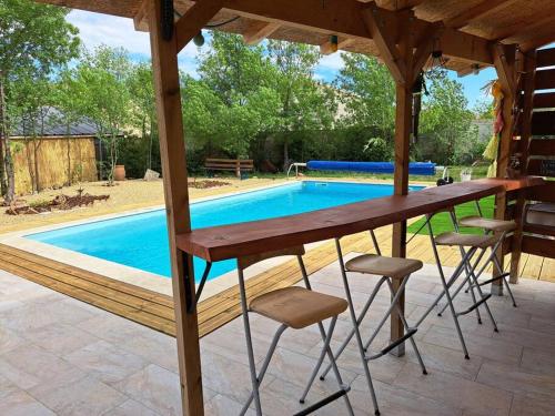 une table et des chaises devant une piscine dans l'établissement Agréable villa avec piscine, à Néffiès