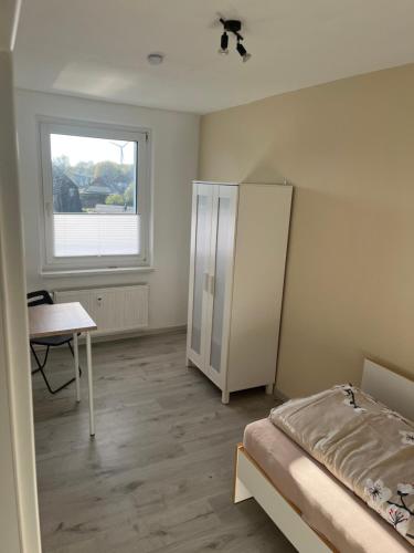 a bedroom with a bed and a desk and a window at Monteur-Pension N2 in Siemitz