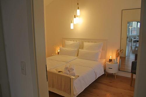 a bedroom with a bed with white sheets and pillows at Chiemsee Apartments in Altenmarkt an der Alz