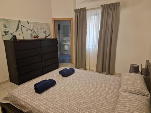 twee blauwe kussens op een bed in een slaapkamer bij Seafront apartment at Waters' Edge in St Paul's Bay