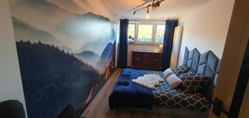 1 dormitorio con 2 camas y un mural de montaña en la pared en Widokówka, en Ustroń