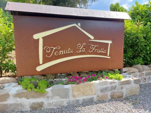 a sign for a house in a garden at Agriturismo Tenuta La Fratta in Bagni di Lucca