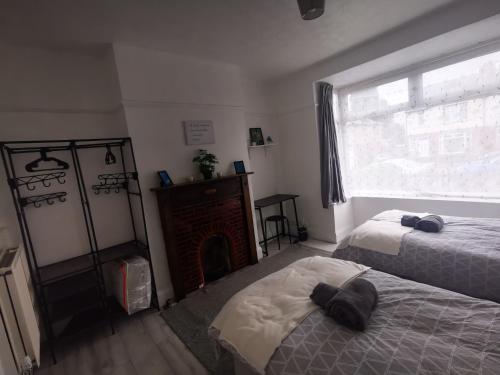 a bedroom with two beds and a fireplace and a window at Peaceful Stay Room 1 - Near Derby City Center in Derby