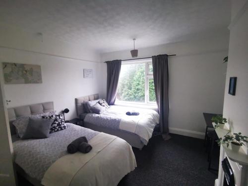 1 dormitorio con 2 camas y ventana en Peaceful Stay Room 1 - Near Derby City Center, en Derby