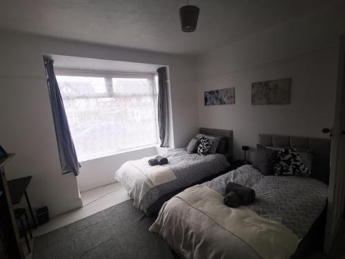 Peaceful Stay Room 1 - Near Derby City Center في ديربي: غرفة نوم بسريرين يوجد عليها حيوانات محشوة