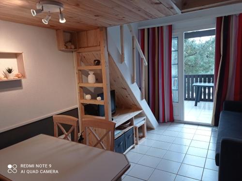 a living room with a staircase and a table at Chez Alex & Max - Appartement duplex entre forêt et océan in Moliets-et-Maa