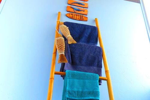 a rack of towels hanging on a blue wall at Casa do Cais in Monte