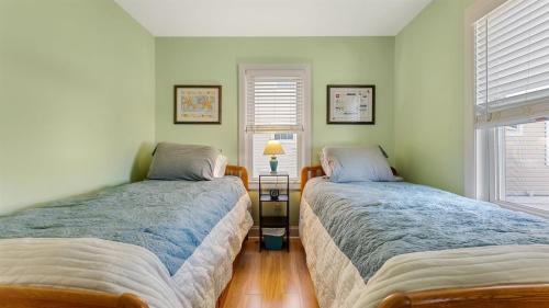 two beds in a room with two windows at 414 E 17th Ave, 2nd Floor in North Wildwood