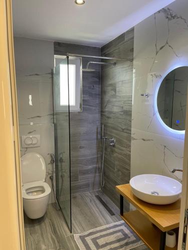 a bathroom with a shower and a toilet and a sink at Resol Hotel in Ksamil