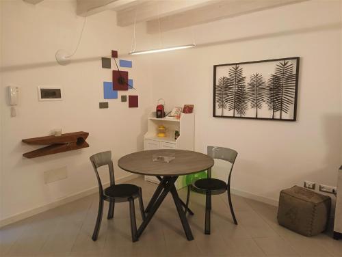 ein Esszimmer mit einem Tisch und 4 Stühlen in der Unterkunft CIVICO22 in Comacchio