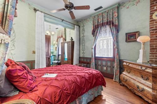 a bedroom with a red bed and a dresser at The Peerless Hotel in Ashland
