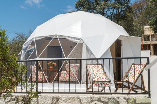 a couple of chairs sitting in front of a tent at Luz de Luna Glamping in Pueblo Nuevo