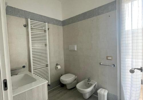 Un baño con inodoro, bañera y lavabo. en La Magnolia Apartments V Sunflower, en Desenzano del Garda