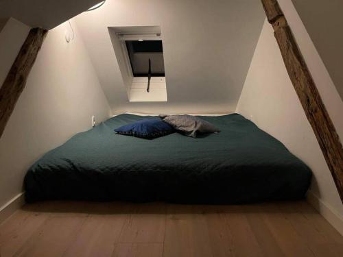 a bedroom with a green bed in a attic at Hyggeligt lille byhus lige mellem havnen og bytorv in Ringkøbing