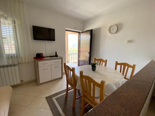 eine Küche und ein Esszimmer mit einem Tisch und Stühlen in der Unterkunft Apartments Giana in Labin