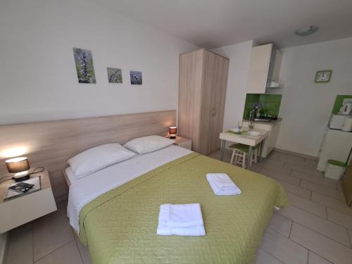 a bedroom with a large bed with two towels on it at Apartments Fran in Baška