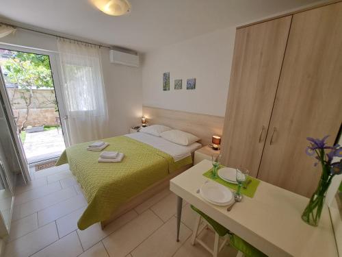 a bedroom with a bed and a table and a window at Apartments Fran in Baška