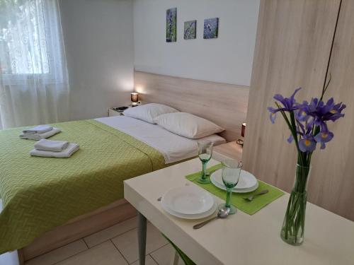 a bedroom with a bed and a table with plates and glasses at Apartments Fran in Baška