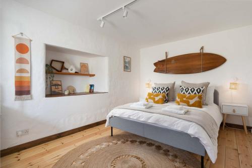 a bedroom with a large bed with yellow pillows at Naut Retreat, The Big Barn - Spacious & cosy cottage, walk to Porthcurno beach, Pedn Vouder & Minack Theatre in Penzance
