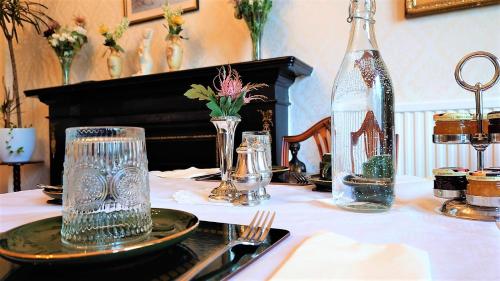 a table with a plate and a bottle on it at Heatherlie House Hotel in Selkirk