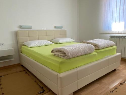 Apartments Giana في لابين: سرير عليه وسادتين في غرفة