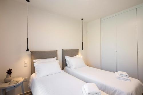 two beds in a room with white sheets at Stablo Residence in Kanálion