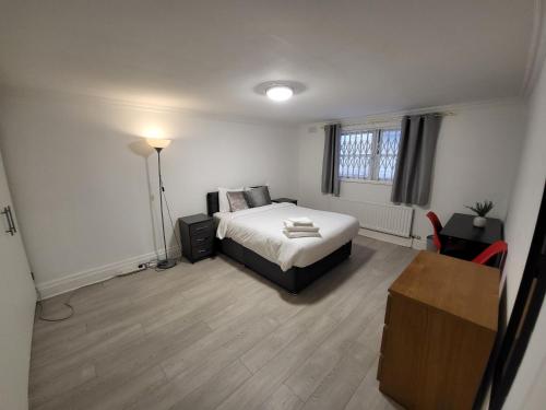 - une chambre avec un lit et un bureau dans l'établissement Cosy Apartment By Clapham South Underground!, à Londres
