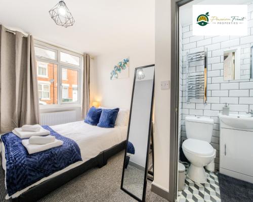 Schlafzimmer mit einem Bett, einem WC und einem Spiegel in der Unterkunft LOWest rate 6 Bedroom House 6 Bath in Coventry - City Centre with garden and FREE wi-fi- RRC in Coventry